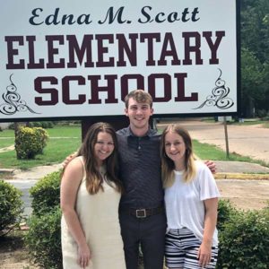 Three students at an internship at Edna M. Scott Elementary School